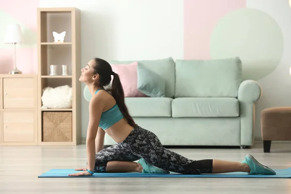 Hermosa joven haciendo ejercicio de fitness en casa — Foto de Stock