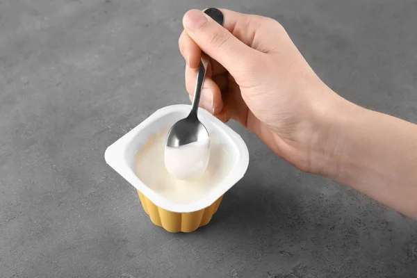 Vrouw Lekkere Yoghurt Eten Aan Grijze Tafel — Stockfoto