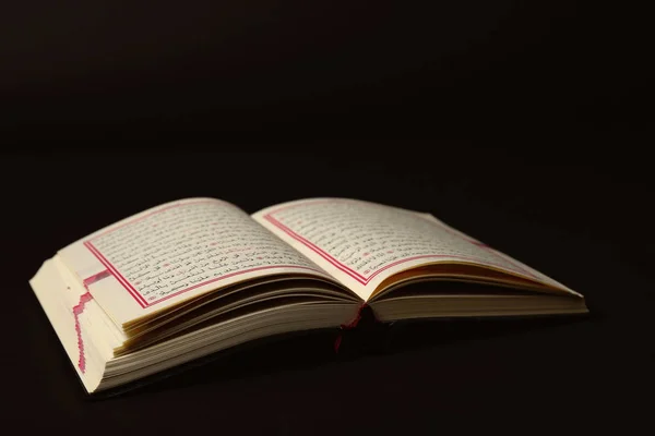 Libro sagrado abierto de los musulmanes sobre fondo negro — Foto de Stock