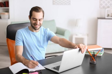 Öğrenci masada kapalı eğitim dizüstü bilgisayar ile