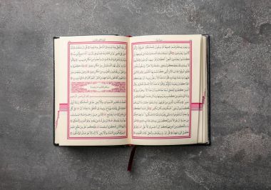 Müslümanların kutsal kitabı gri arka plan üzerinde açılan