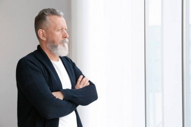 Evde pencere yakınındaki emin olgun adam portresi