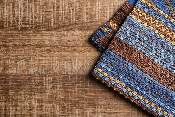 Wzorzyste tkaniny na podłoże drewniane. Tekstura tkanina — Zdjęcie stockowe