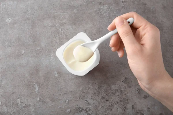 Vrouw Lekkere Yoghurt Eten Aan Grijze Tafel — Stockfoto