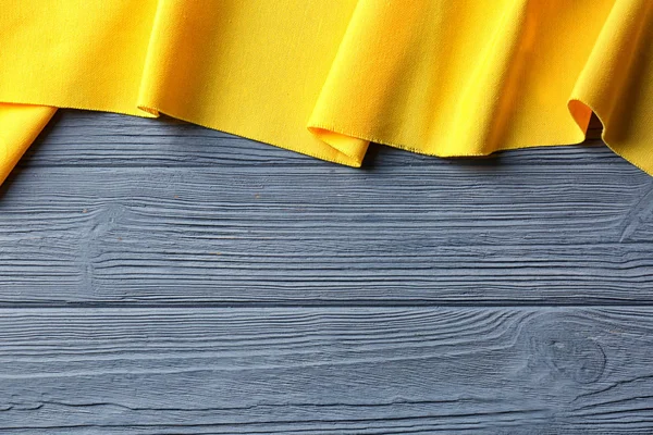 Желтый хлопковый текстиль на деревянном фоне. Текстура ткани — стоковое фото
