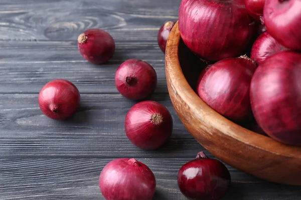 Ciotola con cipolla rossa sul tavolo di legno — Foto Stock