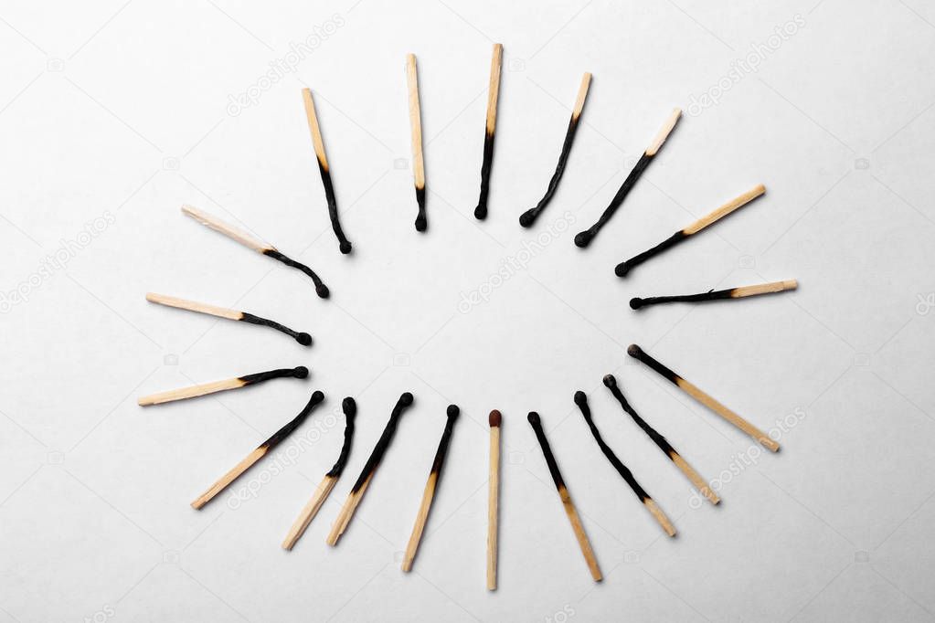 Burnt matchsticks and one different on white background