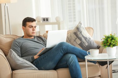 Genç adam ev ofis içinde laptop ile çalışma