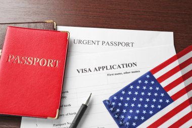 Passports, American flag and visa application form on table. Immigration to USA clipart