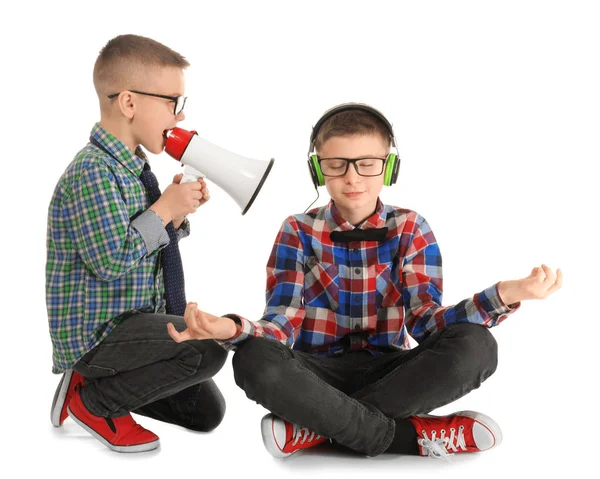 Schattige kleine jongen mediteren en het negeren van zijn vriend met megafoon, op witte achtergrond — Stockfoto