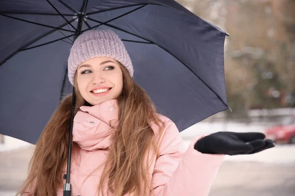 Jonge vrouw met zwarte paraplu buitenshuis — Stockfoto