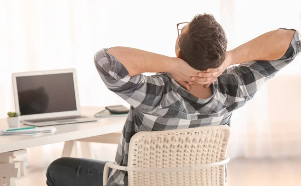 Jonge man in casual kleding rusten op werkplek — Stockfoto