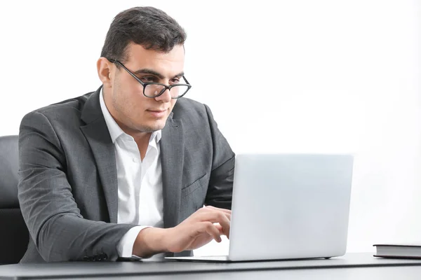 Молодой человек в офисной одежде работает с ноутбуком за столом — стоковое фото