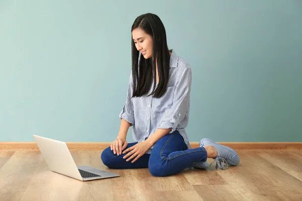 Молодая азиатка использует ноутбук на полу в помещении — стоковое фото