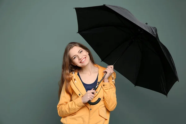 Giovane donna con ombrello nero su sfondo a colori — Foto Stock