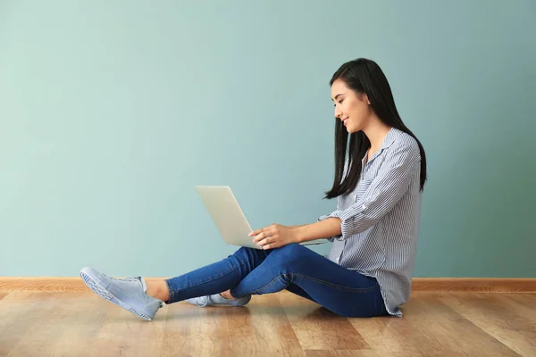 Jovem mulher asiática usando laptop no chão dentro de casa — Fotografia de Stock