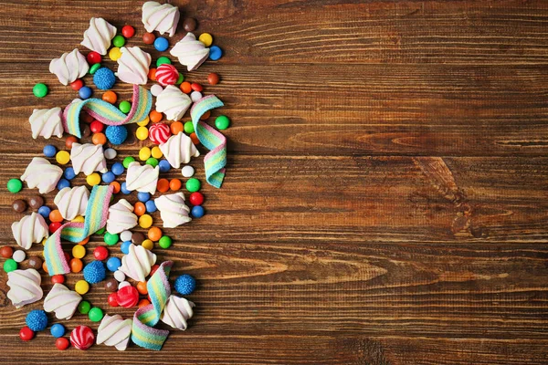 Colorful candies on wooden background — Stock Photo, Image