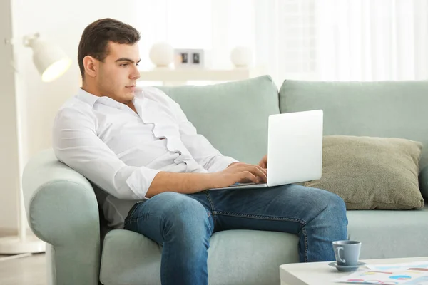 Jeune homme travaillant avec un ordinateur portable dans le bureau à domicile — Photo