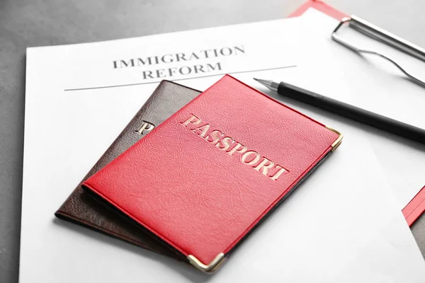 Passeports et feuille de papier avec mots RÉFORME D'IMMIGRATION sur la table — Photo