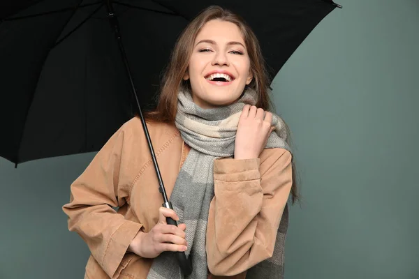 Jovem com guarda-chuva preto no fundo da cor — Fotografia de Stock