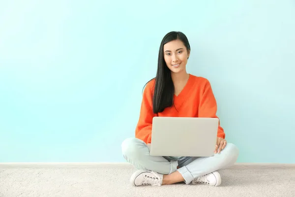 Молодая азиатка использует ноутбук на полу в помещении — стоковое фото