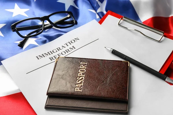 Passports and sheet of paper with words IMMIGRATION REFORM on American flag — Stock Photo, Image