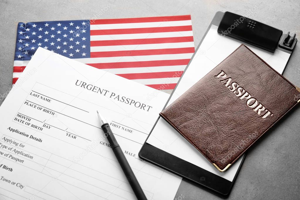 Passport, American flag and application form on table. Immigration to USA