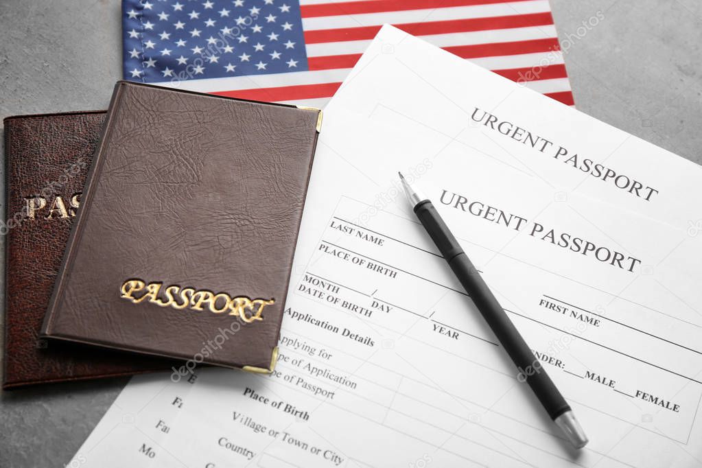 Passports, American flag and application forms on table. Immigration to USA