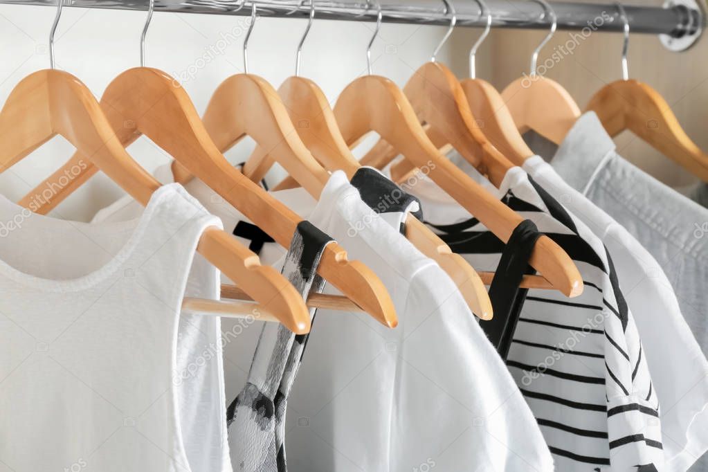 Hangers with different clothes in wardrobe closet