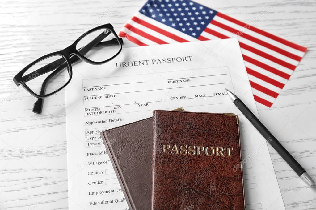 Passports, application form and American flag on table. Immigration to USA