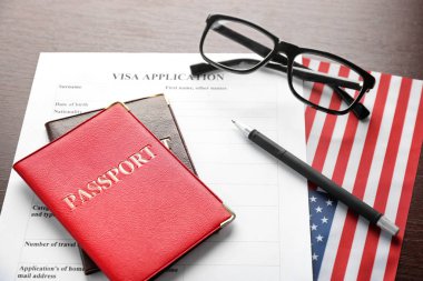 Pasaport, vize başvuru formu ve Amerikan bayrağı masada. ABD Göçmenlik