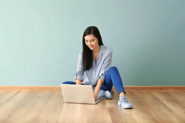 Νεαρή γυναίκα της Ασίας χρησιμοποιούν φορητό υπολογιστή στο πάτωμα σε εσωτερικούς χώρους — Φωτογραφία Αρχείου