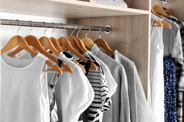 Hangers with different clothes in wardrobe closet — Stock Photo, Image