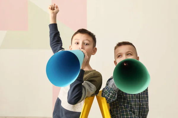 Engraçado meninos com megafones de papel no fundo de cor — Fotografia de Stock