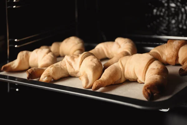 Baking sheet with croissants in oven