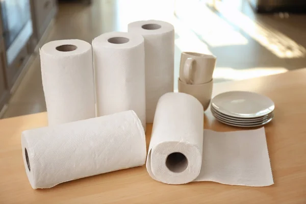 Rollos de toallas de papel y vajilla en la mesa en interiores —  Fotos de Stock