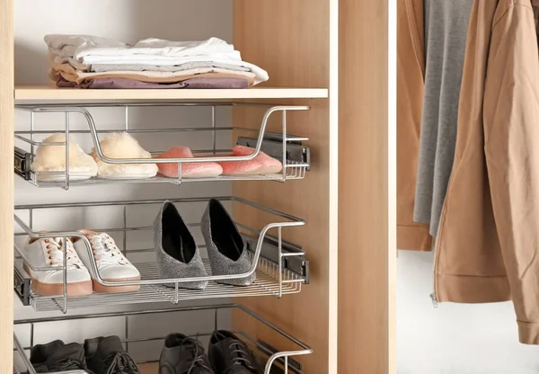 Sapatos diferentes nas prateleiras do armário do guarda-roupa — Fotografia de Stock