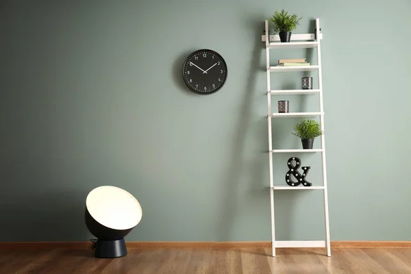 Elegante lámpara con estantería cerca de la pared de color —  Fotos de Stock