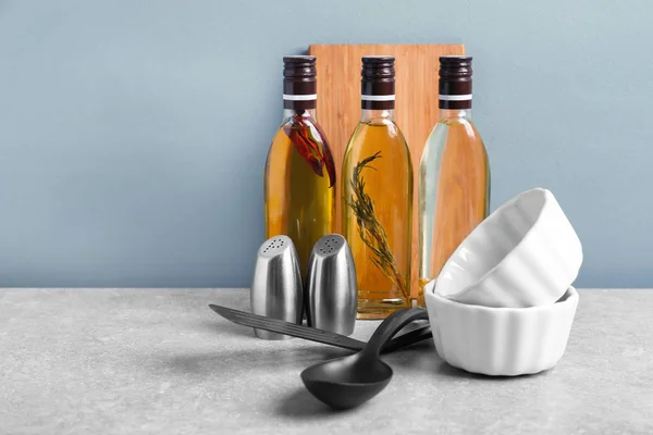 Utensilios de cocina y botellas con aceite sobre la mesa — Foto de Stock