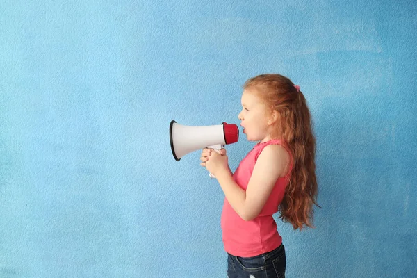 Schattig klein meisje met megafoon op kleur achtergrond — Stockfoto