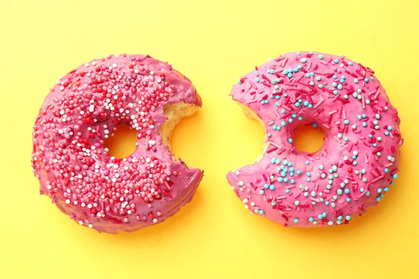 Вкусные розовые пончики на цветном фоне — стоковое фото