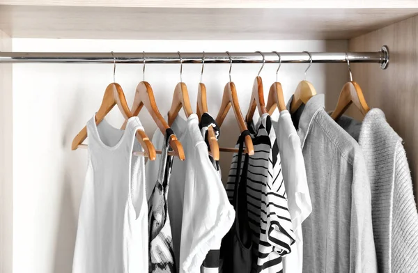 Kleiderbügel mit verschiedenen Kleidungsstücken im Kleiderschrank — Stockfoto