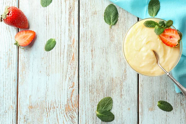 Ciotola da dessert con budino alla vaniglia e fragola su fondo di legno — Foto Stock