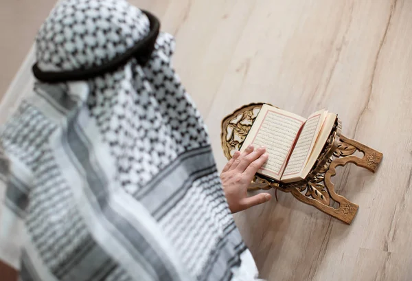 Молодой мусульманин читает Коран в помещении — стоковое фото