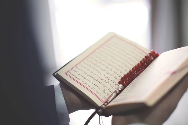 Молодой мусульманин читает Коран, крупным планом — стоковое фото