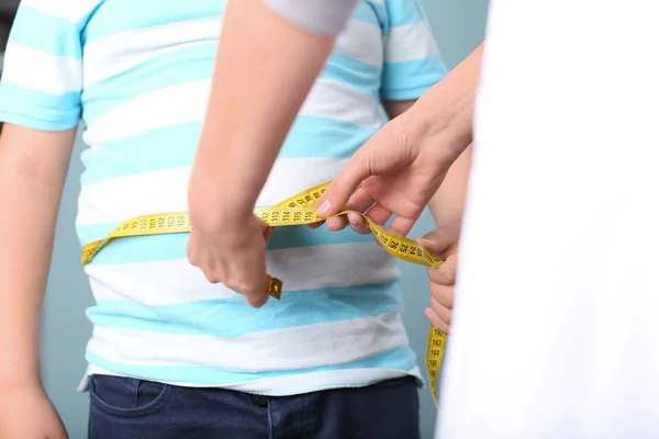 Doctor measuring overweight boy in clinic — Stock Photo, Image