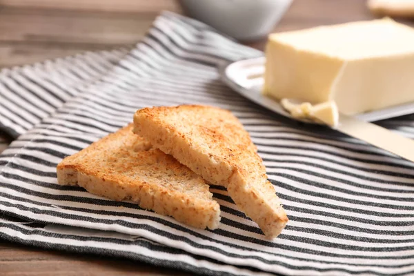 Вкусный поджаренный хлеб и масло на салфетке — стоковое фото