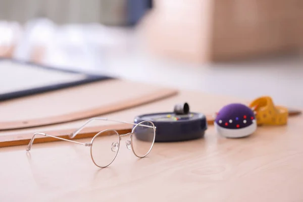 Gafas y herramientas de sastrería en la mesa en el taller —  Fotos de Stock