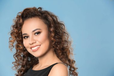 Renk arka plan üzerinde uzun dalgalı saçlı güzel genç Afro-Amerikan kadın