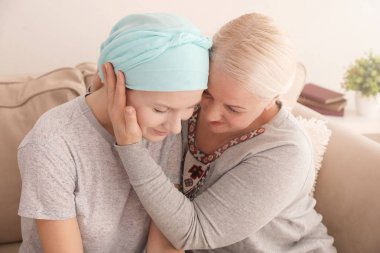 Mature woman visiting her daughter with cancer indoors clipart